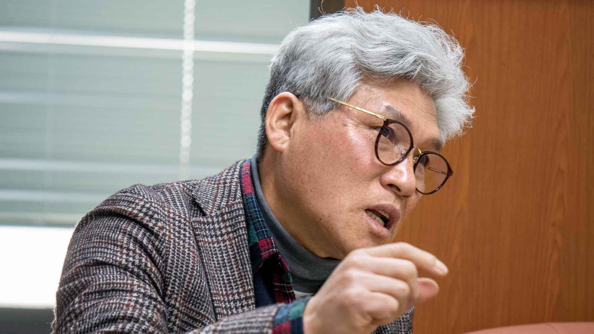 백발 남성이 인터뷰에 응하고 있다. 