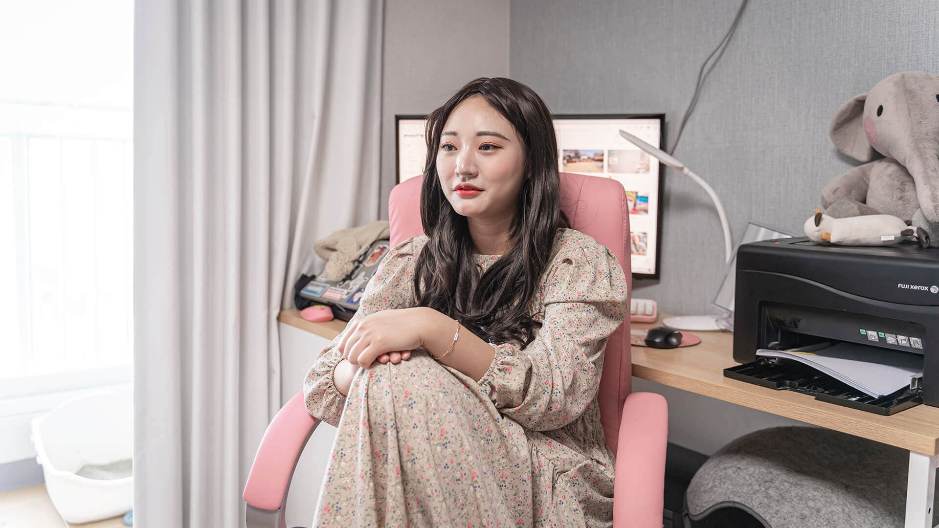 컴퓨터 앞에 한 여성이 앉아 있다.