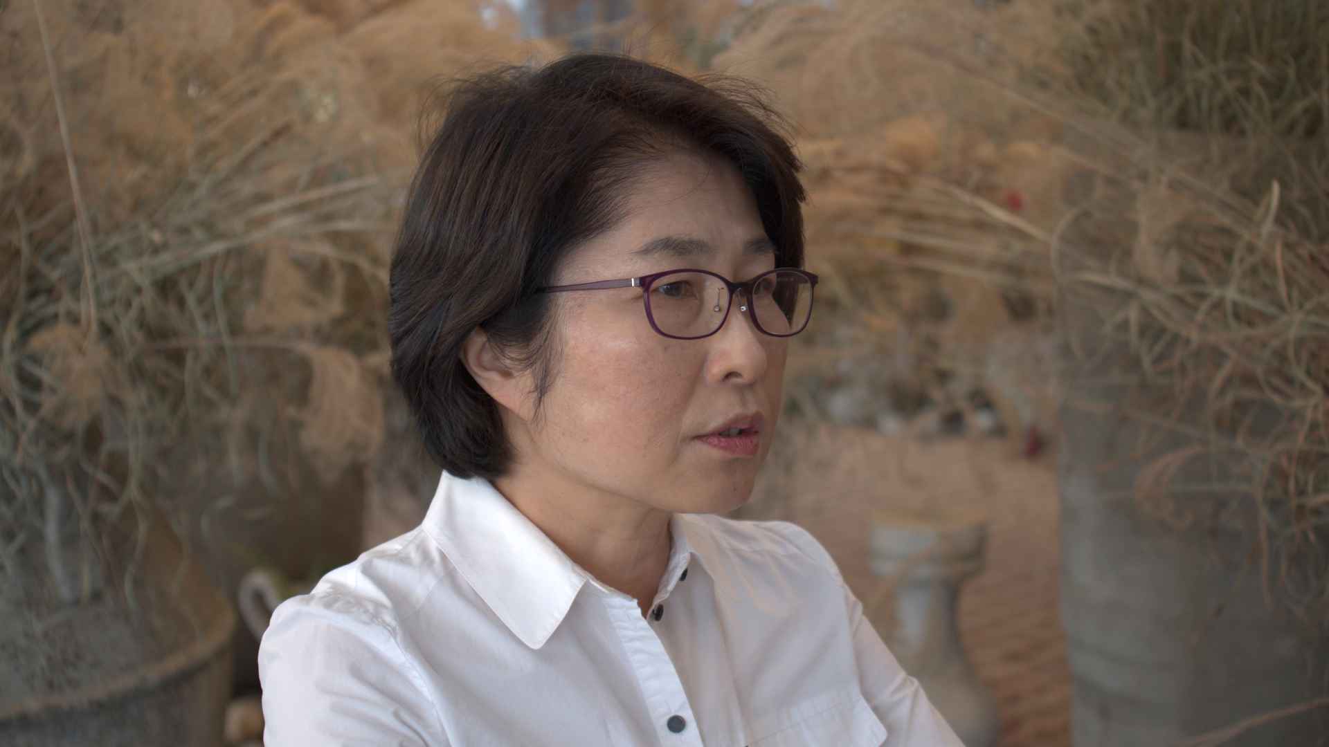 정은주씨가 인터뷰에 응하고 있다. 단발머리를 하고, 흰색 셔츠와 안경을 착용했다. 