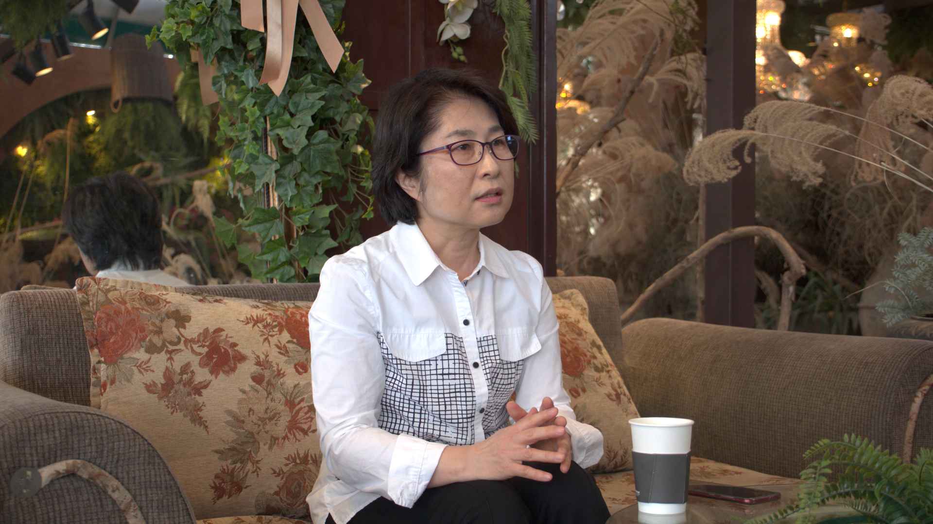 정은주씨가 인터뷰에 응하고 있다. 단발머리를 하고, 흰색 셔츠와 안경을 착용했다. 