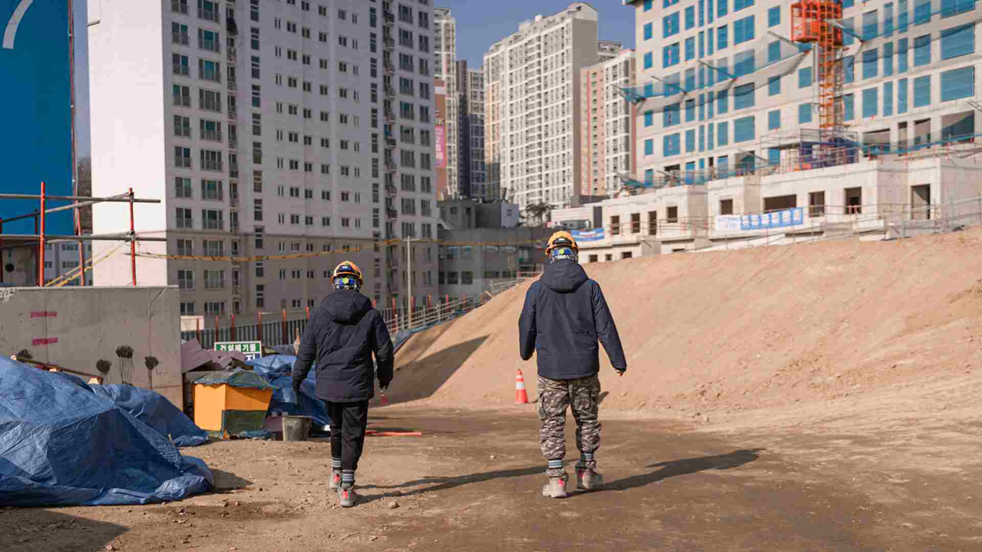건설 현장 작업자들의 걸어가는 뒷모습.