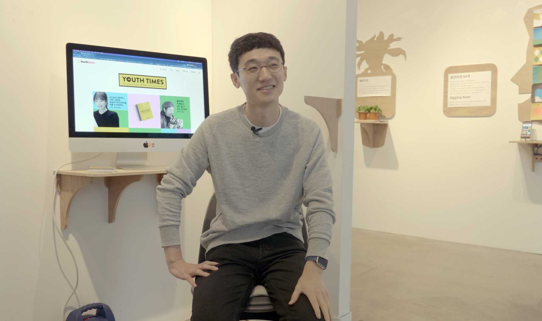 안경을 쓴 30대 남성이 의자에 앉아 인터뷰에 응하고 있다.