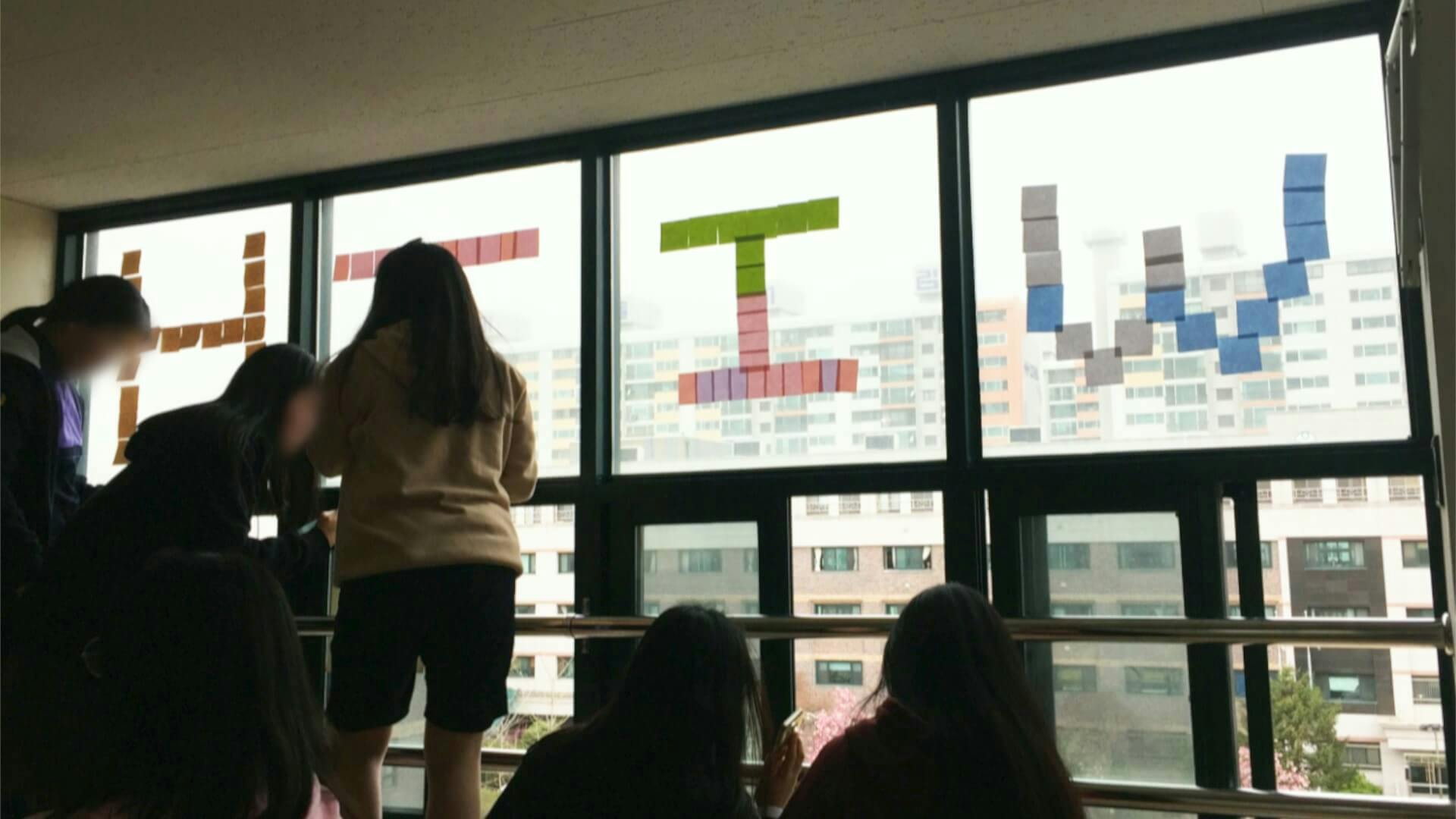 2018년 4월 6일, 용화여자고등학교 재학생들이 창문에 포스트잇으로 'WITH YOU' 문구를 붙이는 모습(ⓒ용화여고 페이스북)